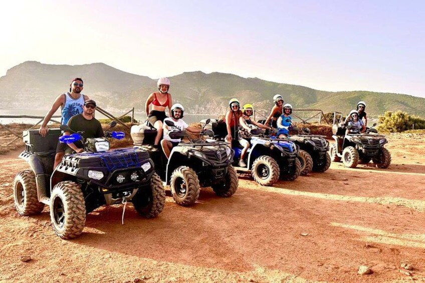 A group of people on ATVs in a desert landscape with mountains in the background. 1