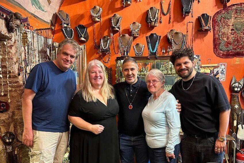A group of people in a jewelry store with various necklaces and bracelets on display. 3