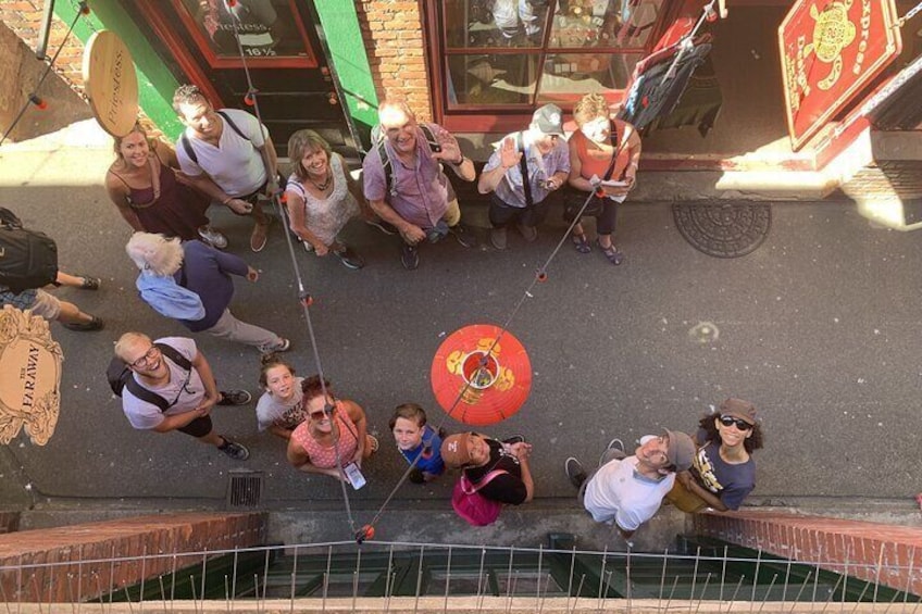 A group of people gathered around a water feature with a red circular decoration in the center. 5