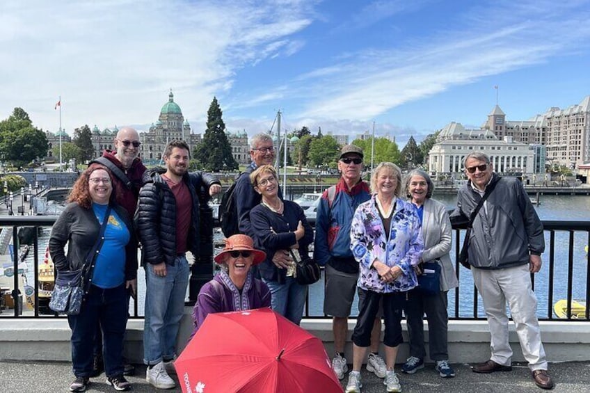A group of people standing by a waterfront with buildings in the background. 3