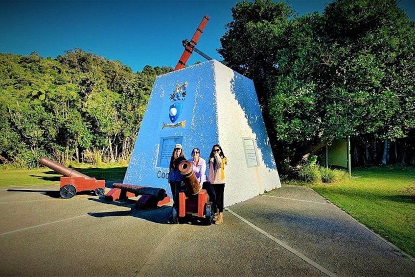 A blue and white monument with a cannon, a telescope, and a plaque. 4