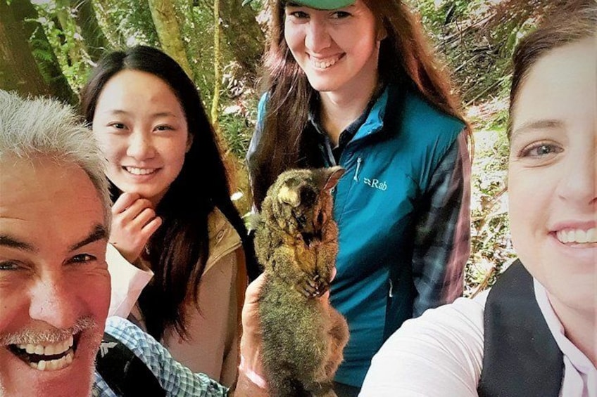 A group of people outdoors with a small animal. 3
