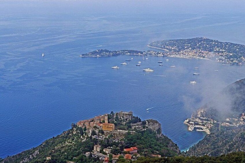 A coastal town with a prominent castle on a hill, surrounded by water and boats. 5