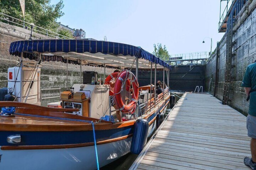 A boat docked at a pier with a lifebuoy and a covered area. 4