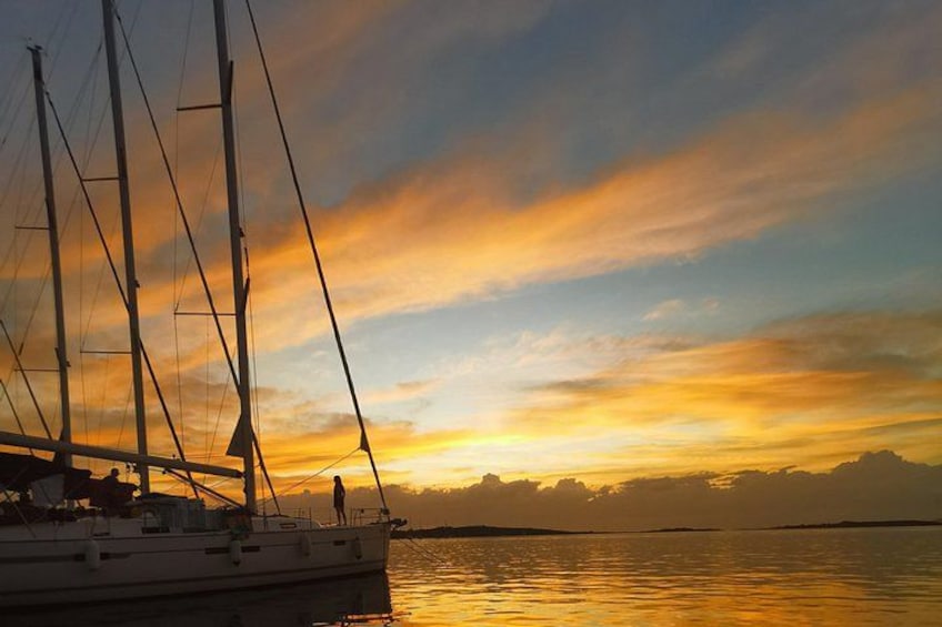 Een zeilboot op kalm water tijdens de zonsondergang met een kleurrijke lucht. 1