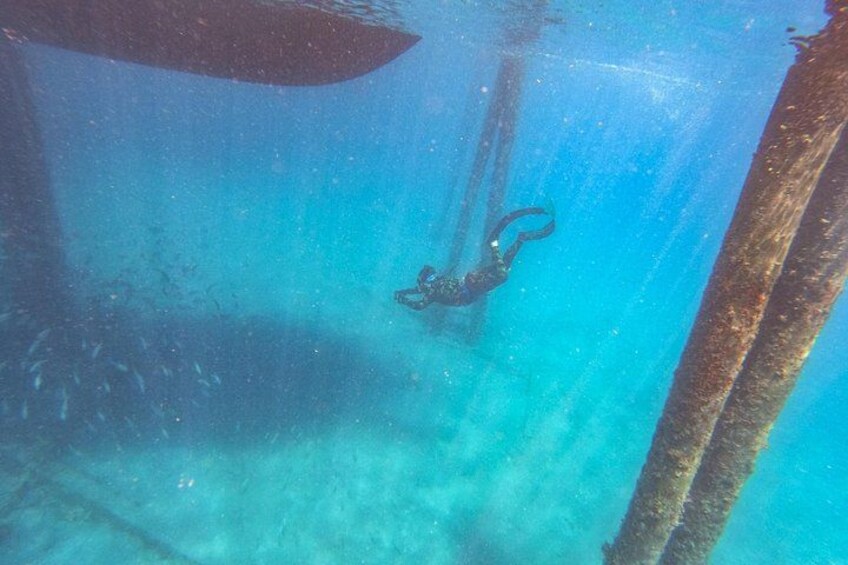 A diver underwater near a submerged structure. 4