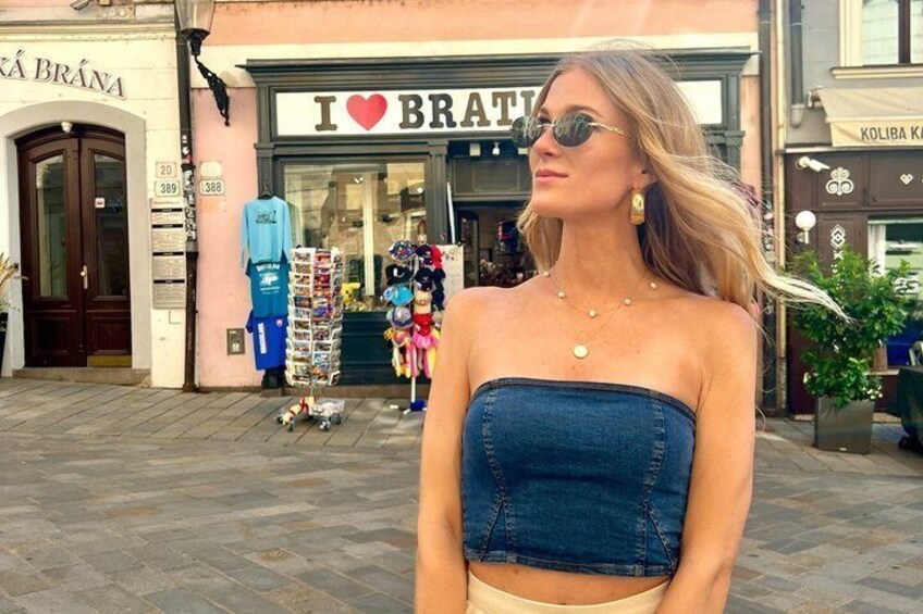 Una persona in piedi di fronte a un negozio con un cartello che dice 'I ♥ BRATTI'. 3