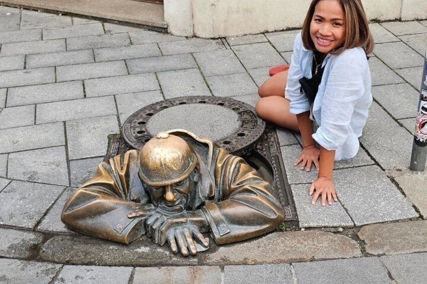 Una statua in bronzo raffigura una persona inginocchiata su una superficie pavimentata. 4