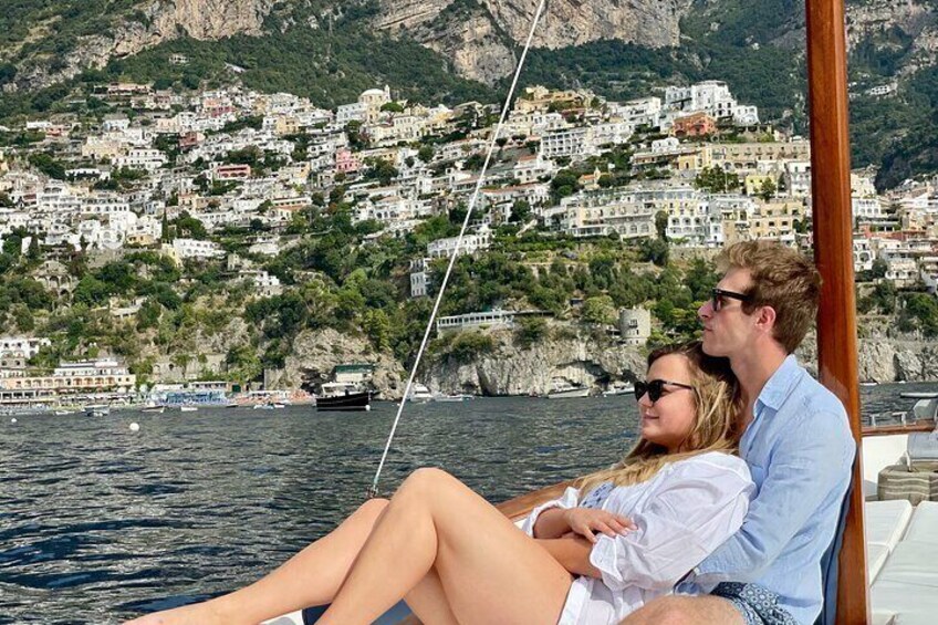 Una pareja en un barco con un pueblo costero al fondo. 4