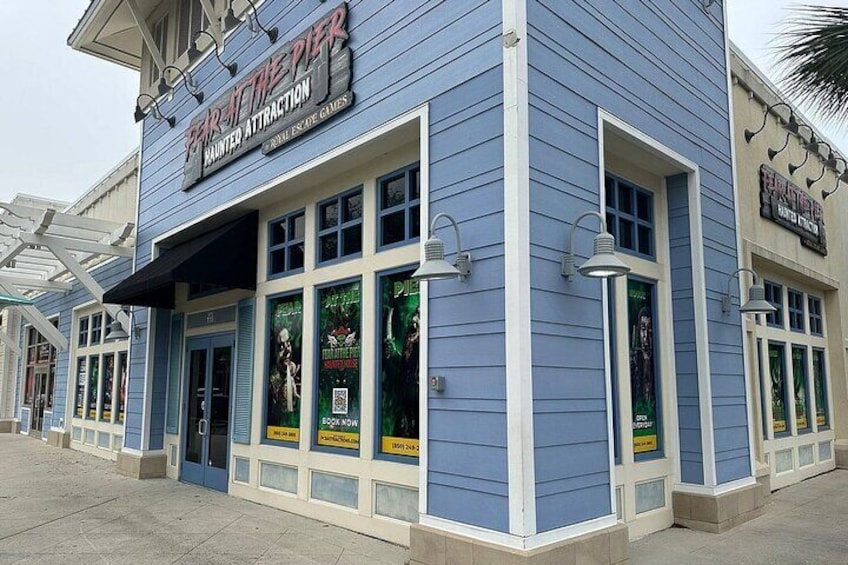 A building with a sign that reads "Haunted Attraction." 1