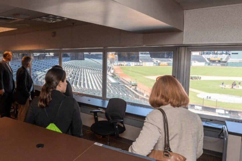 People in an office with a view of a baseball field. 2