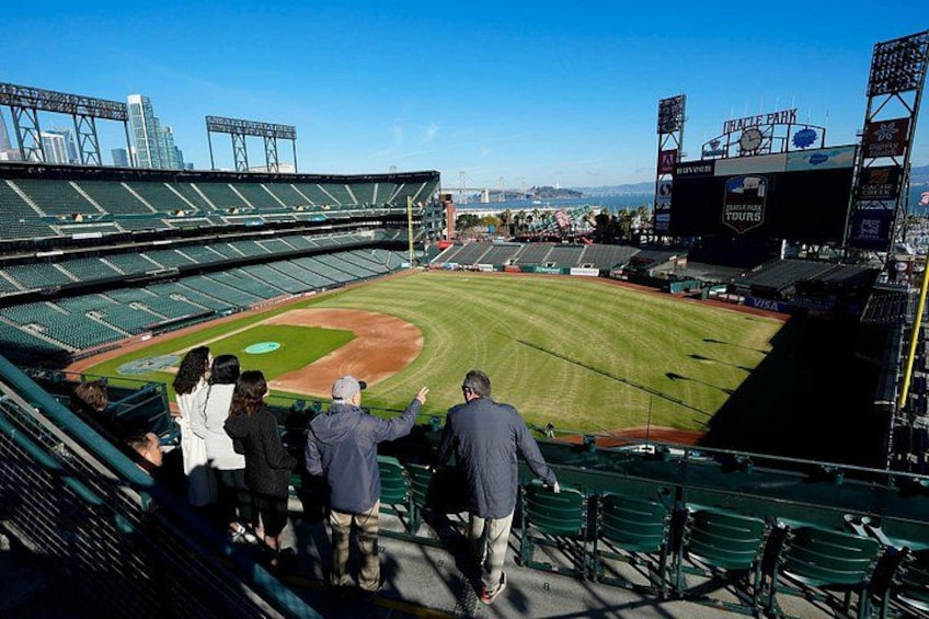 Un estadio de béisbol con asientos verdes, un diamante de béisbol y un marcador. 2