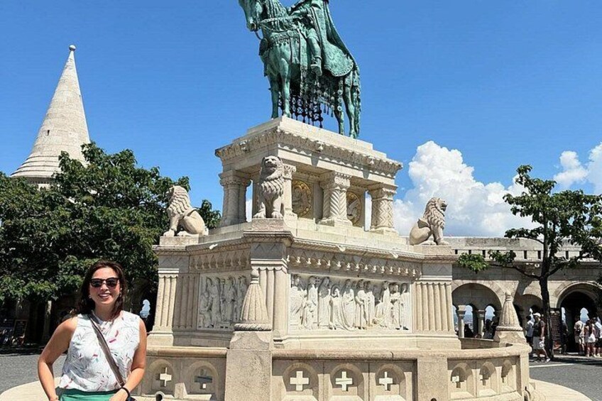 A statue of a man on horseback, a stone monument with carvings, and a clear blue sky. 4
