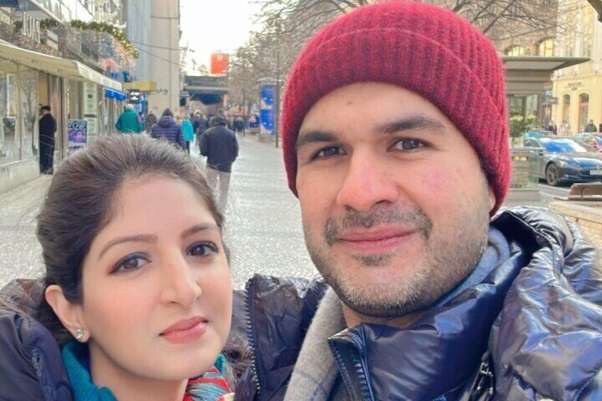 A person in a red beanie and a blue jacket taking a selfie with another individual. 2