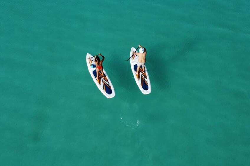 Two paddleboarders on turquoise water. 5