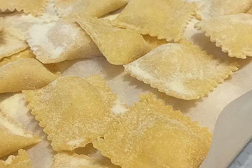 Een schaal ravioli met een laagje bloem. 2