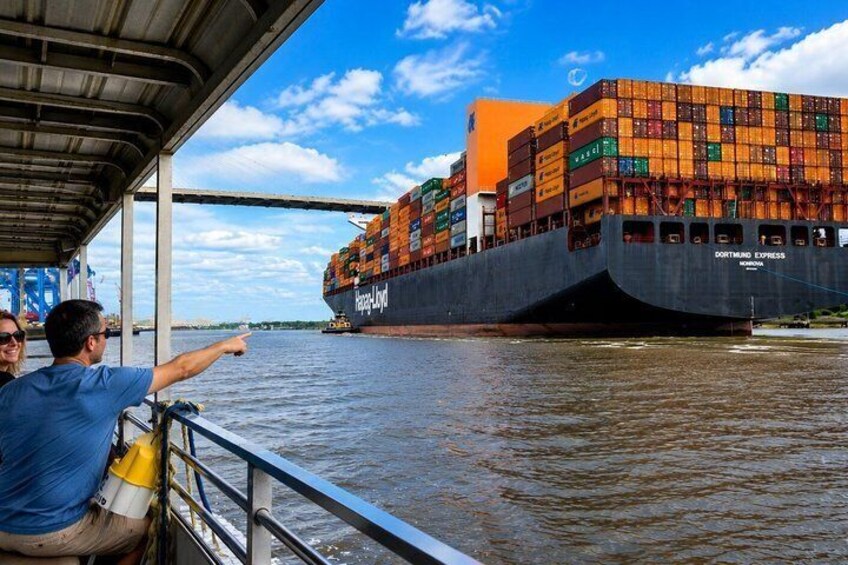 Una grande nave cargo, denominata 'Dortmund Express', è attraccata in un porto con un ponte sopraelevato. 3