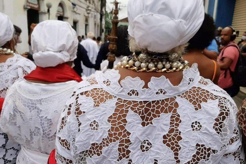 Un grupo de personas con vestidos de encaje blanco y pañuelos en la cabeza, caminando en una procesión. 3