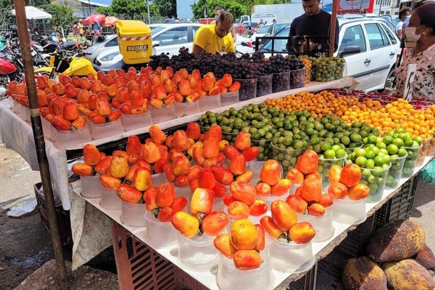 Un puesto de frutas con diversas frutas como naranjas, manzanas y uvas. 5