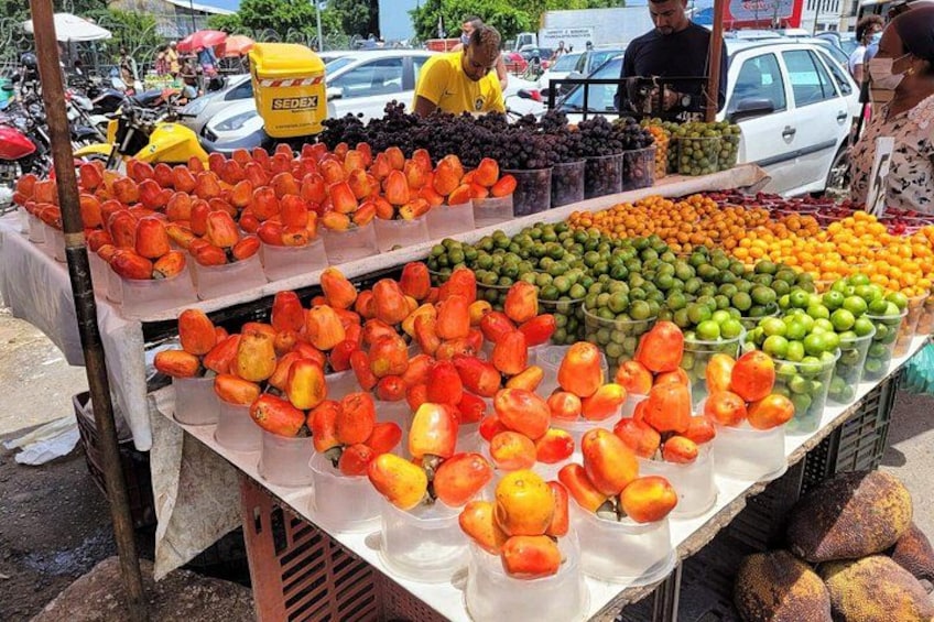 Un puesto de frutas con diversas frutas como naranjas, manzanas y uvas. 3
