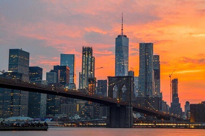 A city skyline with a prominent bridge and skyscrapers during sunset. 3