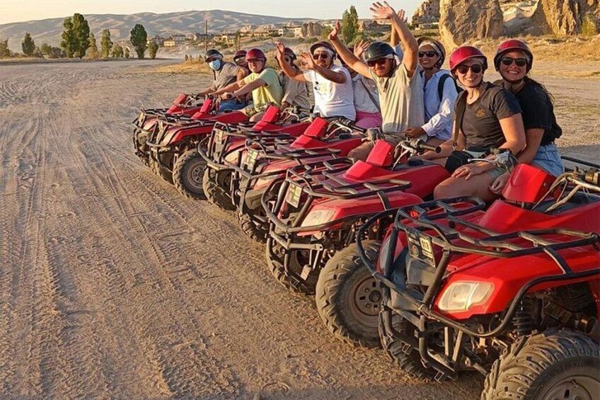 En gruppe mennesker på røde firehjulstrækkere på en grusvej. 3