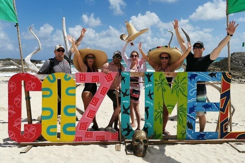 A beach with people holding surfboards and a large colorful sign. 4