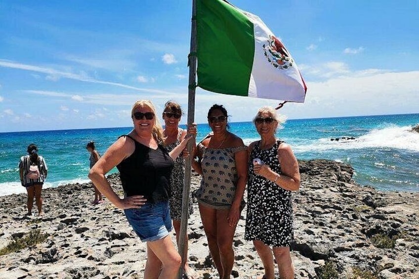 A group of people on a rocky beach with a flag. 2