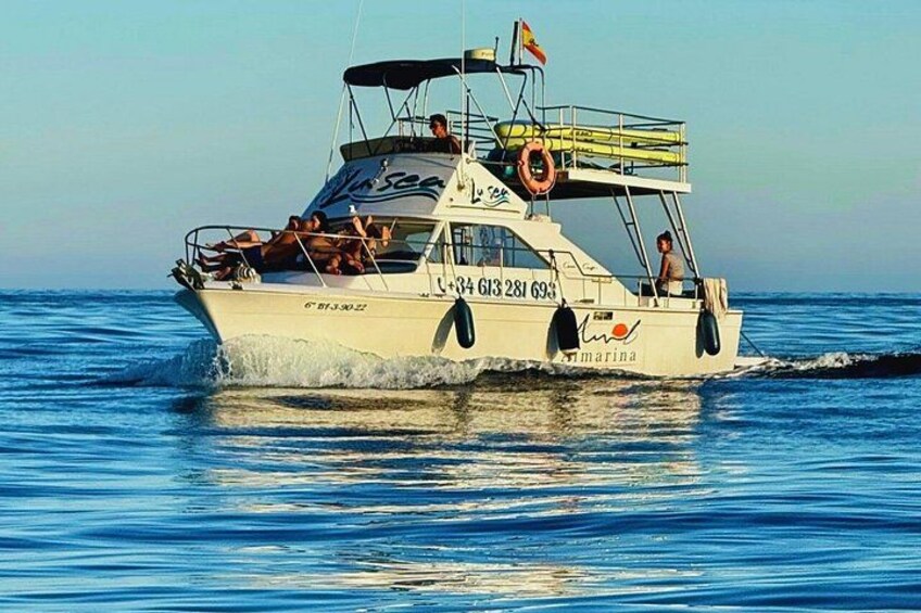A boat named 'Marina' with people on board, moving through blue water. 2