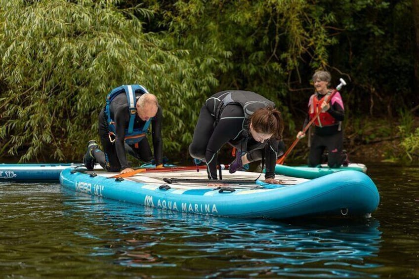 People on a blue inflatable raft with 'AQUA MARINA' written on it, preparing to paddle. 4