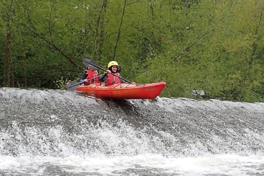 Un kayak rouge navigue sur une rivière où se trouve une cascade. 3