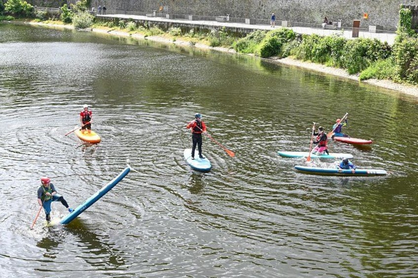 People paddleboarding on a calm river. 2