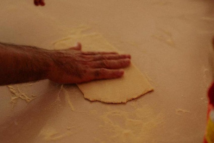 A hand pressing a flat, round object onto a surface. 4