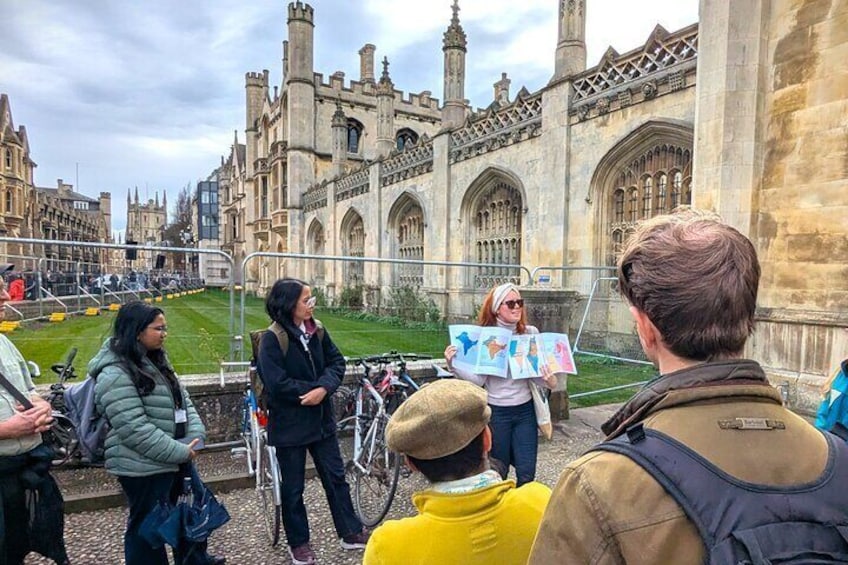 A group of people standing in front of a historic building with arched windows and towers. 2