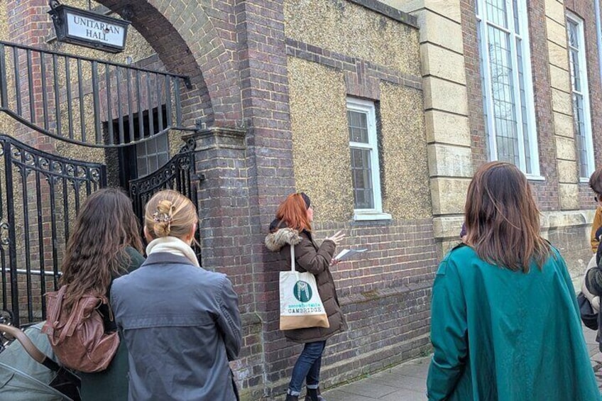A group of people standing in front of a building with a sign that reads "UNITARIAN HALL". 4