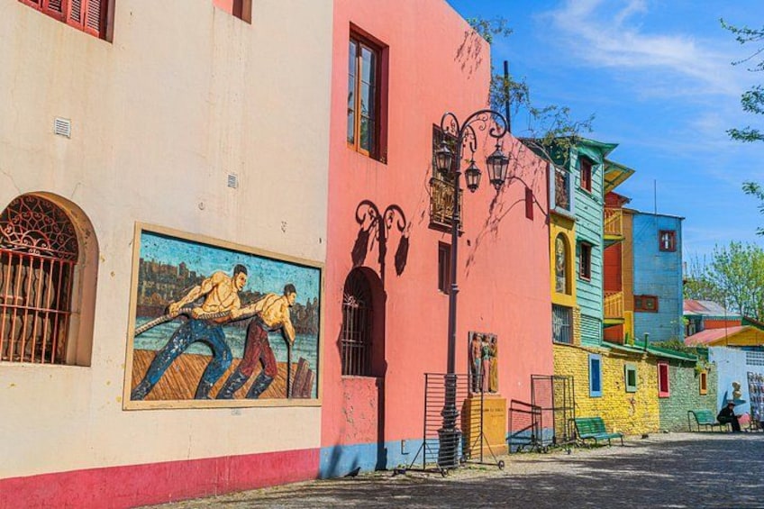 Calle colorida con un mural de dos hombres quitando nieve. 3