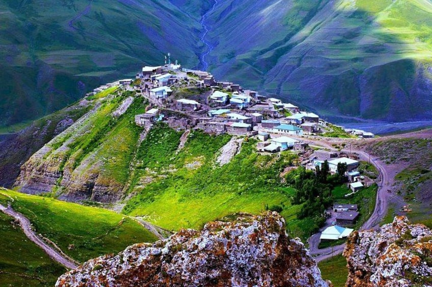 A village on a hillside with buildings and a road. 1