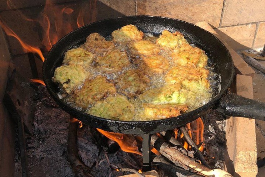 Una sartén sobre fuego abierto, cocinando comida. 2