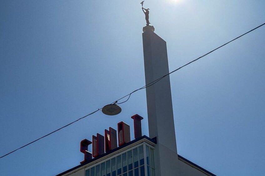 Un edificio con una chimenea alta y una estatua en la parte superior. 5