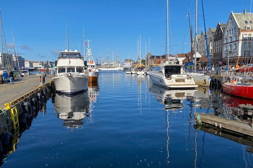 Un puerto deportivo con barcos amarrados, un muelle de madera y edificios a lo largo de la costa. 2