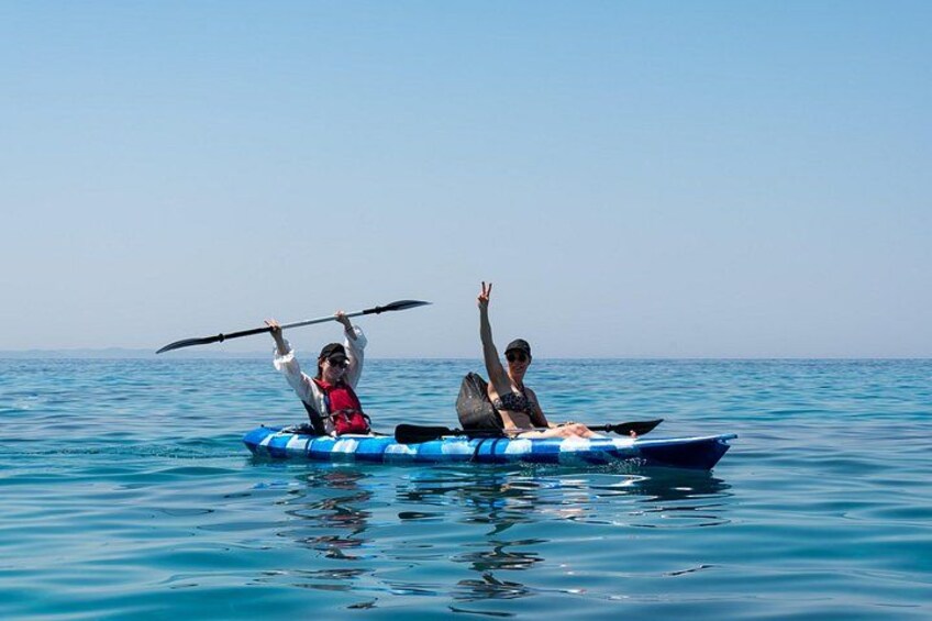 Two people kayaking on a calm sea. 4