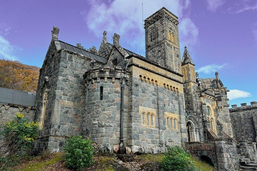 A historic stone building with a tower, arched windows, and a turret. 2