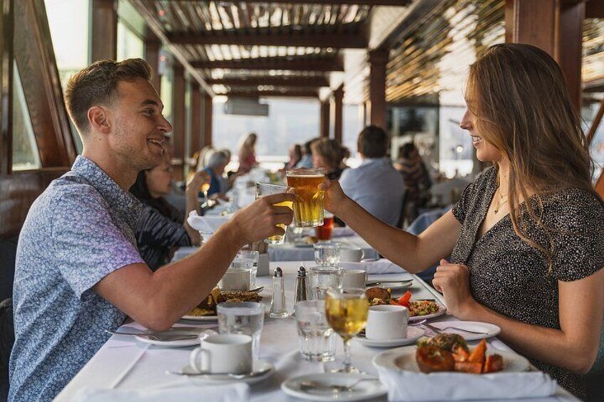 A couple toasting with a drink at a restaurant with a view. 1
