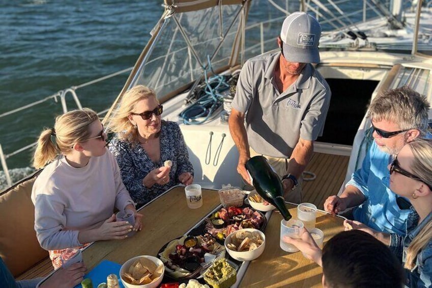 Un groupe de personnes se trouve sur un bateau, autour d’une table dressée pour un repas. 5
