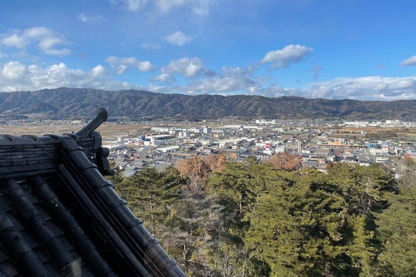 A cityscape with mountains in the background, a traditional roof, and a clear sky. 4