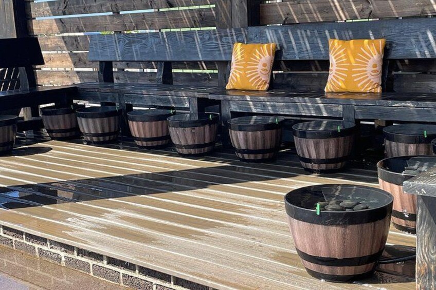 Outdoor wooden barrels arranged in rows on a wooden deck. 1