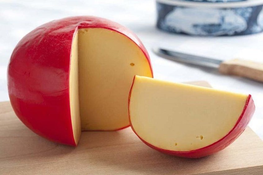 Ett rött äpple med en utskuren skiva, placerat på en träyta. 3