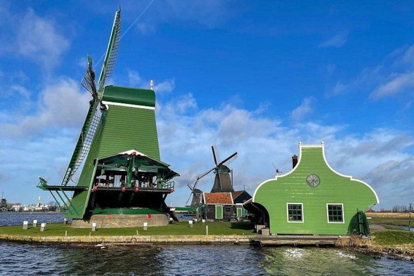 A windmill, a green house, and a body of water. 2