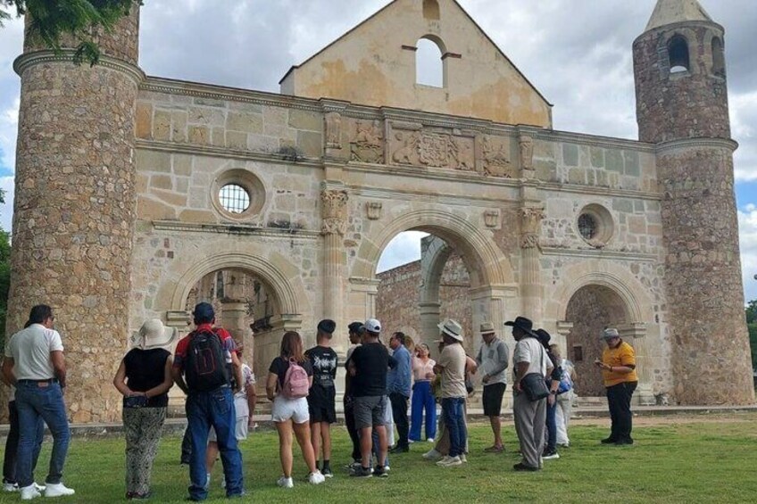 A historic stone building with an arched entrance and a bell tower. 4