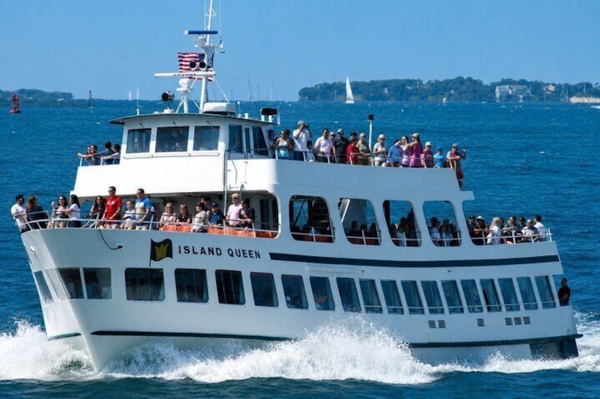 A white boat named 'Island Queen' with passengers on deck, sailing on blue water. 4